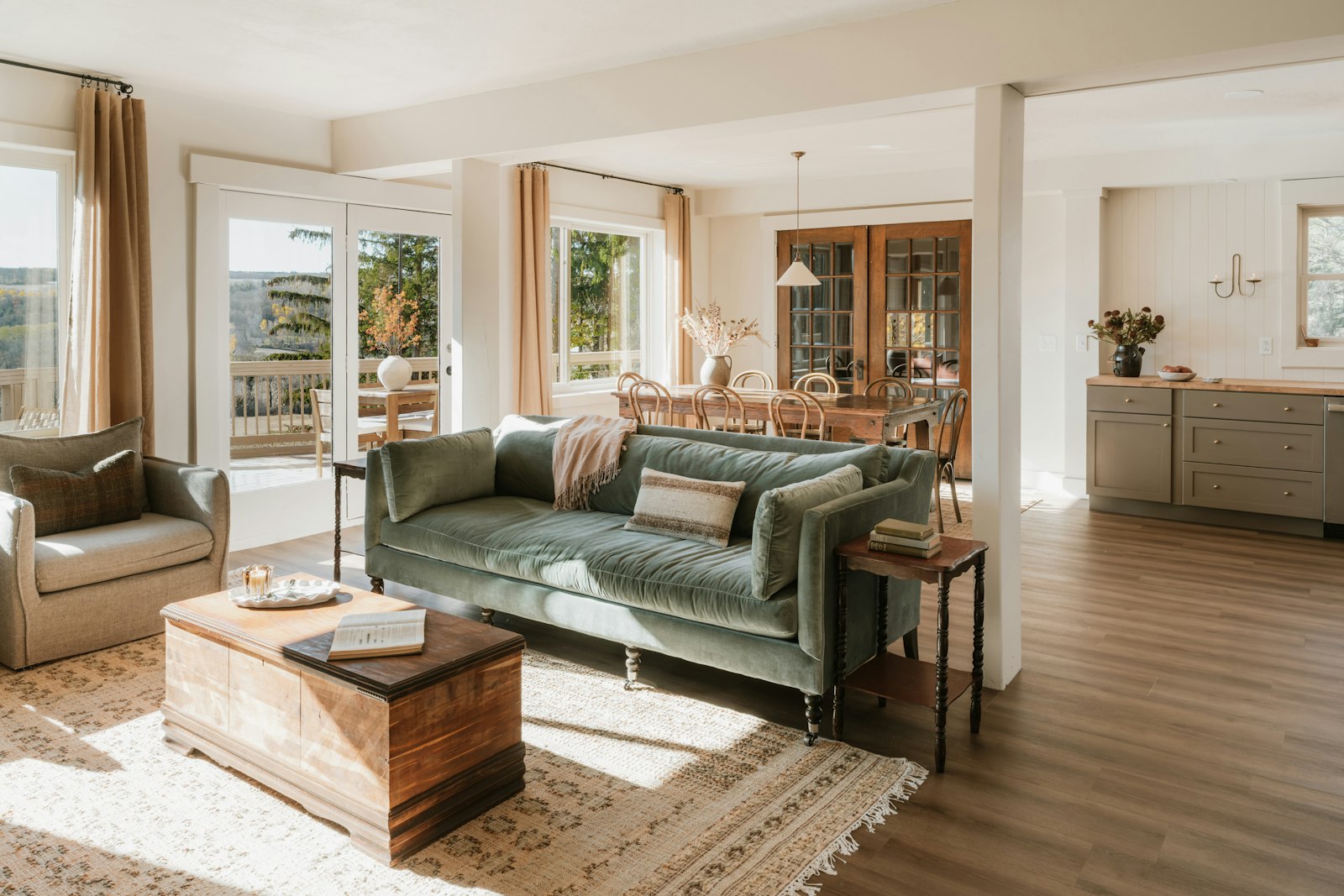 Bright, cozy living room with a green velvet sofa and vintage rug